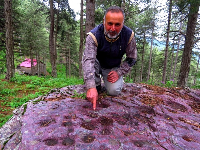 Hatay'ın Erzin ilçesi Amanos Dağları'ndaki kaya parçası üzerinde yer alan biçimli şekillerin doğal olarak mı oluştuğu yoksa yüzyıllar önce insanlar tarafından mı yapıldığı merak